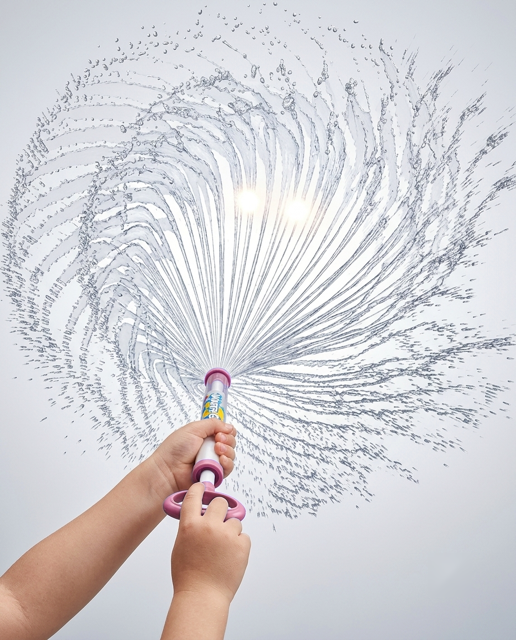 Enfant utilisant le pistolet à eau rose, jet en spirale puissant en éventail